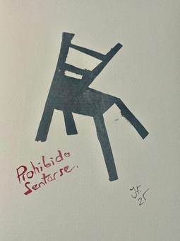 Una silla gris con la advertencia «prohibido sentarse»